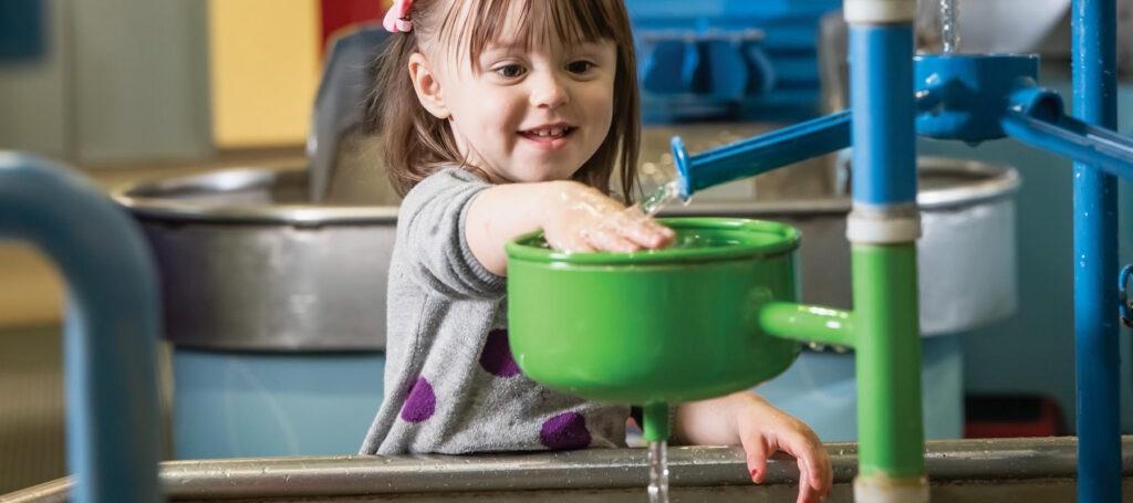 Child playing with water toy at Discovery Center