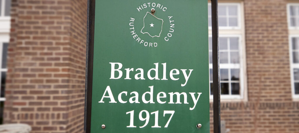 Green sign showing Bradley Academy established in 1917